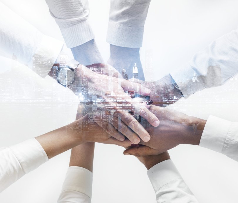 Business team joining hands together city background